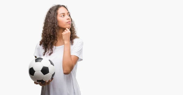 Mujer Hispana Joven Sosteniendo Pelota Fútbol Cara Seria Pensando Pregunta —  Fotos de Stock