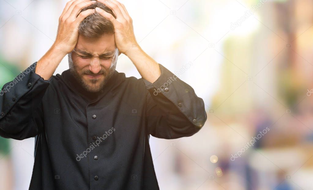 Young catholic christian priest man over isolated background suffering from headache desperate and stressed because pain and migraine. Hands on head.