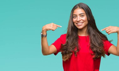 Yüzünde gülümseme ile kendinden emin görünüyorsun, kendini gururlu ve mutlu parmakları ile işaret izole arka plan genç güzel Arap kadın.