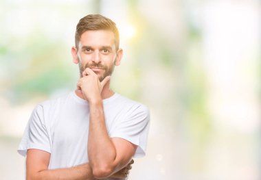 Yakışıklı delikanlı emin çapraz kollar ve çeneme kaldırdı el ile gülümseme ile kameraya bakarak izole arka plan üzerinde. Pozitif düşünce.