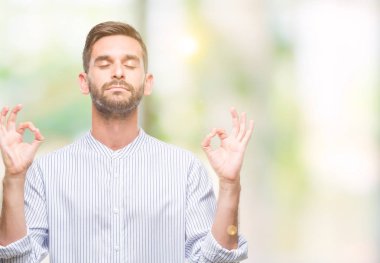 Yakışıklı delikanlı izole arka plan üzerinde dinlenmek ve gülümseyen gözlerle parmak ile meditasyon jest yapıyor kapalı. Yoga kavramı.
