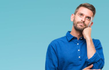 Yakışıklı delikanlı çene düşünme hakkında soru, dalgın ifade üzerine el ile izole arka plan üzerinde. Düşünceli yüzüyle gülümsüyor. Şüphe kavramı.