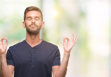 Yakışıklı delikanlı izole arka plan üzerinde dinlenmek ve gülümseyen gözlerle parmak ile meditasyon jest yapıyor kapalı. Yoga kavramı.
