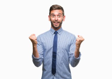 Genç yakışıklı iş adamı izole arka plan kutlama üzerinde şaşırttı ve başarı için kaldırdı kollarını açarak hayret ve gözleri açık. Kazanan kavramı.