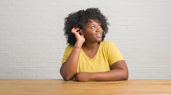 Mujer Afroamericana Joven Sentada Mesa Casa Sonriendo Con Mano Sobre — Foto de Stock