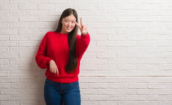 Jonge Chinese Vrouw Bakstenen Muur Glimlachend Zoek Naar Camera Vingers — Stockfoto