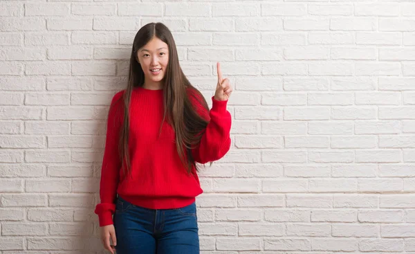 Unga Kinesiska Kvinnan Över Tegelvägg Visar Och Pekar Uppåt Med — Stockfoto
