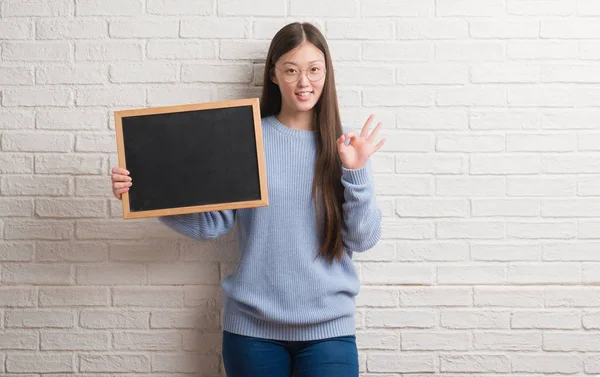 Jonge Chinese Vrouw Bakstenen Muur Holding Schoolbord Doen Teken Met — Stockfoto