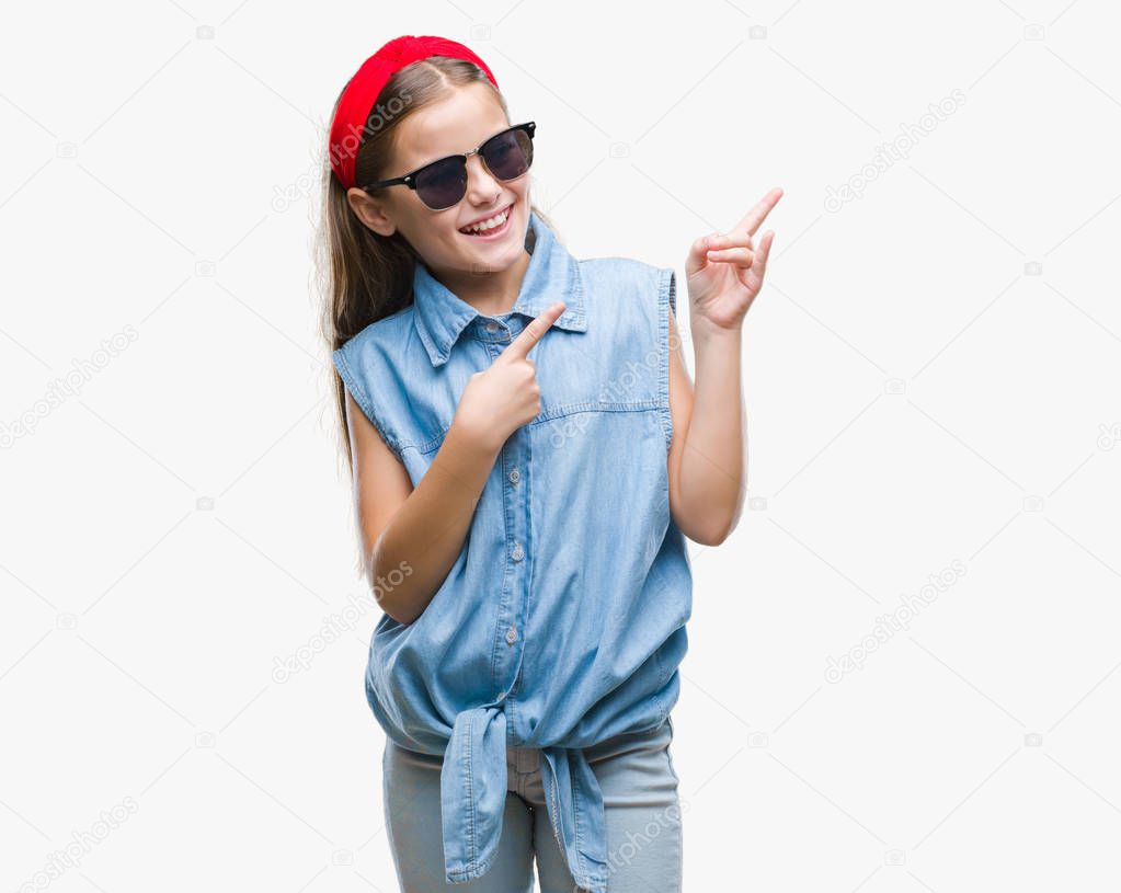 Young beautiful girl wearing sunglasses over isolated background smiling and looking at the camera pointing with two hands and fingers to the side.
