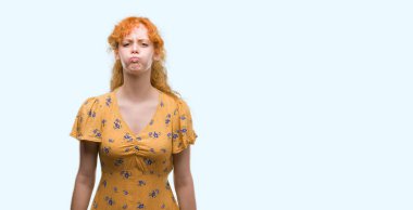 Komik surat ile yanakları şişirme genç Kızıl saçlı kadın. Ağız ile hava, deli ifade şişirilmiş.