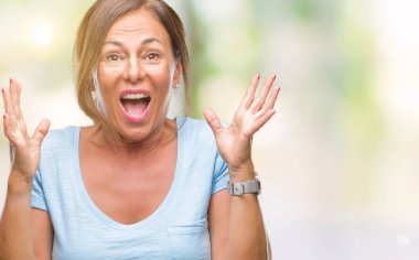 Orta yaş üst düzey İspanyol kadın yüzünden kızgın ve silah ile başarı için deli kutluyor izole arka plan ortaya çıkar ve heyecanlı çığlık gözler kapalı. Kazanan kavramı