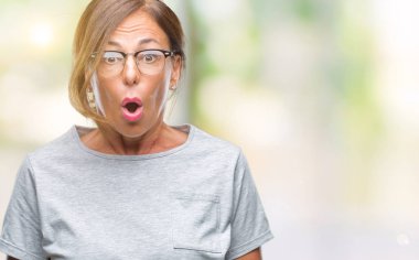 Orta yaş İspanyol kadın kıdemli gözlük korkuyor ve şok sürpriz ifade ile izole arka plan üzerinde korku ve yüz heyecanlı.