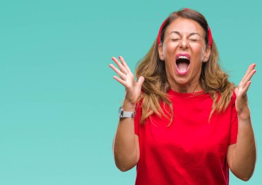 Orta yaş üst düzey İspanyol kadın yüzünden kızgın ve silah ile başarı için deli kutluyor izole arka plan ortaya çıkar ve heyecanlı çığlık gözler kapalı. Kazanan kavramı