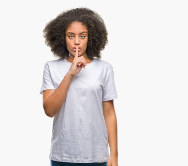 Dudaklarında parmak ile sessiz olmanı izole arka plan üzerinde genç afro Amerikalı kadın. Sessizlik ve gizli kavramı.