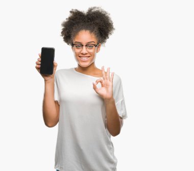 Genç güzel afro Amerikan gösteren smartphone ekran parmak, mükemmel sembolü ile ok işareti yapıyor izole arka plan üzerinde