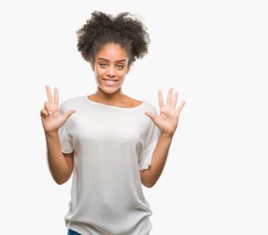 Genç afro Amerikan kadın gösterilen ve parmakları ile işaret izole arka plan yüzünden kendinden emin ve mutlu gülümseyerek süre sekiz numara.