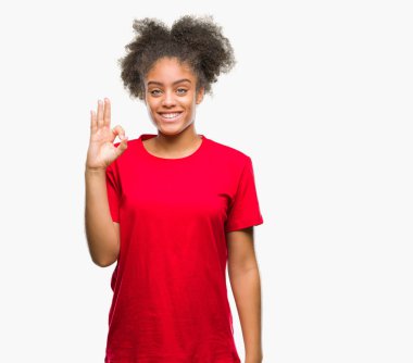 Gülümseyen izole arka plan üzerinde genç afro Amerikalı kadın el ve parmaklar ok işaretiyle yapıyor olumlu. Başarılı ifade.