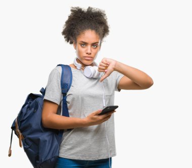 Sırt çantası tutan genç güzel afro Amerikan öğrenci kadın arka plan kızgın yüzü, eksi işareti aşağı antipati başparmak ile gösterilen, ret kavramı ile izole