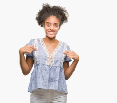 Yüzünde gülümseme ile kendinden emin görünüyorsun, kendini gururlu ve mutlu parmakları ile işaret izole arka plan üzerinde genç afro Amerikalı kadın.