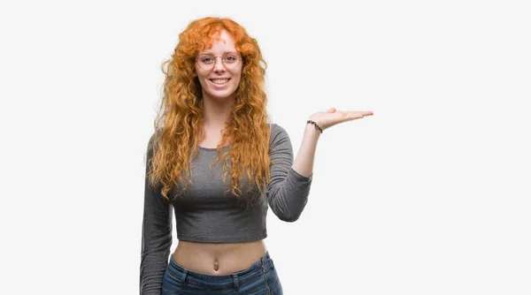 Genç Kızıl Saçlı Kadın Gülümseyen Neşeli Sunulması Kameraya Bakarak Avucunun — Stok fotoğraf
