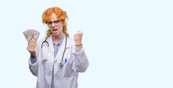 赤毛の若い医師女性持株ドル イライラと不満の叫びと怒り狂ったと概念を怒り 挙手で叫んで — ストック写真