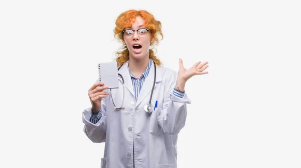 Młoda Ruda Kobieta Lekarz Trzymając Pusty Notatnik Bardzo Szczęśliwy Podekscytowany — Zdjęcie stockowe