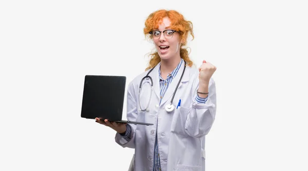 感情を応援赤毛の若い医師の女性が誇りに思って叫んでと勝利と非常に興奮して 成功を祝ってのコンピューター ノート パソコンを保持 — ストック写真