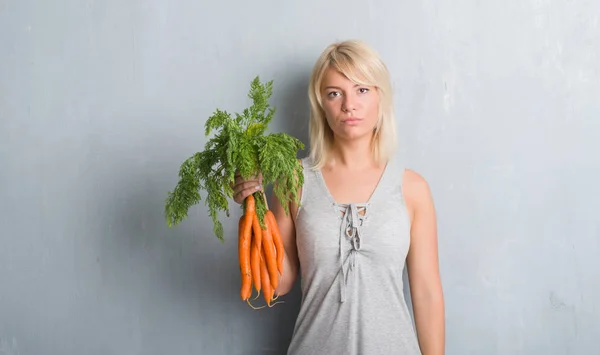 Kaukasische Volwassen Vrouw Grijs Grunge Muur Houden Van Verse Wortelen — Stockfoto