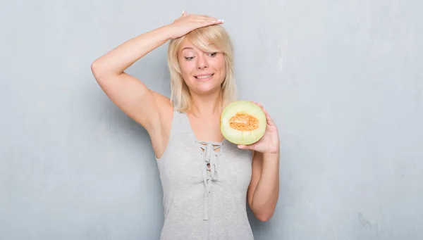 Dorosły Kaukaski Kobieta Streszczenie Szary Mur Jedzenie Melon Kantalupa Podkreślił — Zdjęcie stockowe
