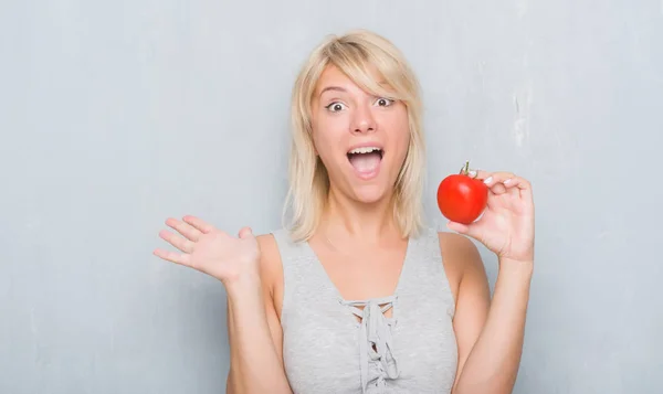 Erwachsene Kaukasische Frau Über Grunge Graue Wand Mit Frischer Tomate — Stockfoto