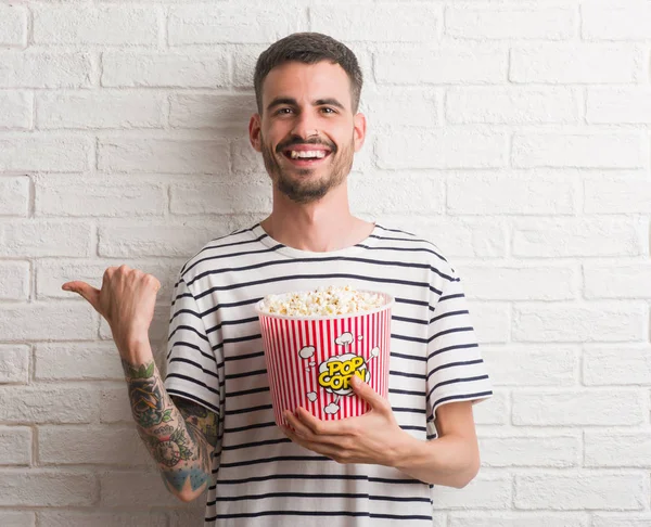 Jonge Volwassen Man Eten Popcorn Staande Witte Bakstenen Muur Aan — Stockfoto