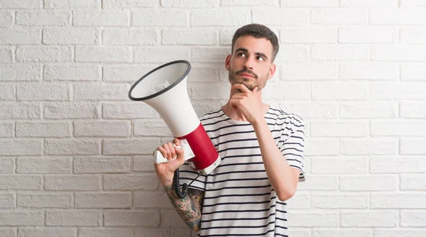 Megafon ciddi bir yüz düşünme hakkında soru, çok karışık fikir tutan genç yetişkin adam