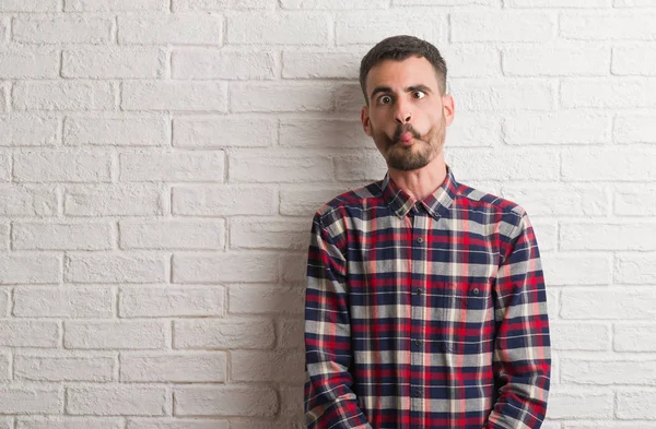 Homem Adulto Jovem Sobre Parede Tijolo Branco Fazendo Cara Peixe — Fotografia de Stock