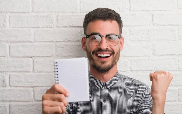 Giovane Uomo Adulto Possesso Notebook Piedi Sopra Muro Mattoni Bianchi — Foto Stock