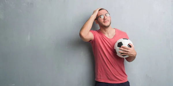 Junger Kaukasischer Mann Über Grauer Grunge Wand Fußballball Gestresst Mit — Stockfoto