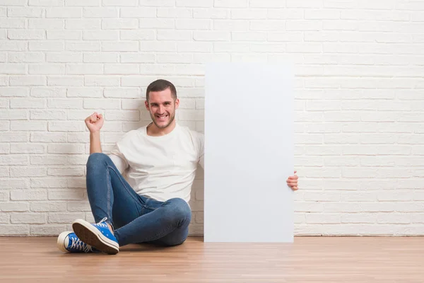 Junger Kaukasischer Mann Sitzt Über Weißer Backsteinmauer Und Hält Eine — Stockfoto