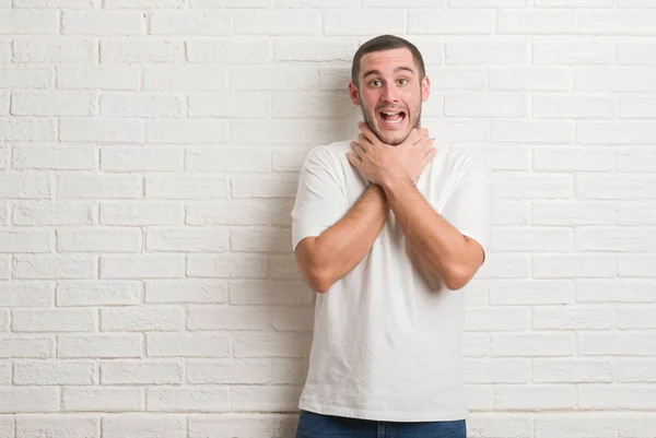 Junger Kaukasischer Mann Der Über Einer Weißen Ziegelwand Steht Und — Stockfoto