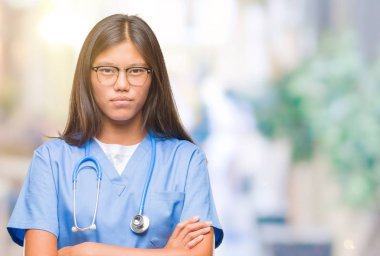 Genç Asyalı doktor kadın izole arka plan şüpheci ve çapraz kolları olan yüzündeki gergin, onaylamayan ifade yüzünden. Negatif kişi.