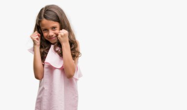 Gülümseyen ve başarı için çığlık çok mutlu ve heyecanlı kaldırdı, silah ile kazanan jest yapıyor pembe elbise giymiş esmer İspanyol kız. Kutlama kavramı.