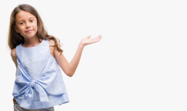 Esmer Latin kız gülümseyen neşeli sunulması ve kameraya bakarak avucunun ile işaret.