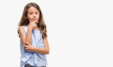 Esmer İspanyol kız emin çapraz kollar ve çeneme kaldırdı el ile gülümseme ile kameraya bakıyor. Pozitif düşünce.