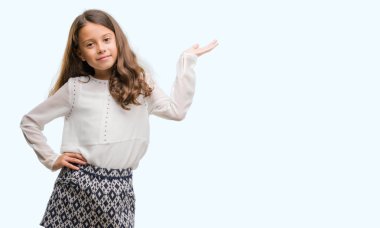 Esmer Latin kız gülümseyen neşeli sunulması ve kameraya bakarak avucunun ile işaret.