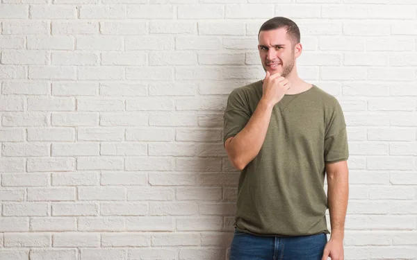 Joven Hombre Caucásico Pie Sobre Pared Ladrillo Blanco Mirando Con — Foto de Stock