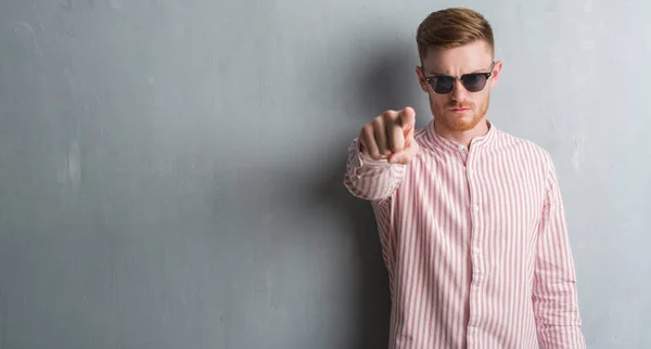 Young Redhead Man Grey Grunge Wall Wearing Sunglasses Pointing Finger — Stock Photo, Image
