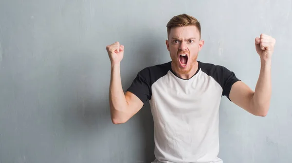 Joven Pelirrojo Sobre Gris Pared Grunge Enojado Loco Levantando Puño — Foto de Stock