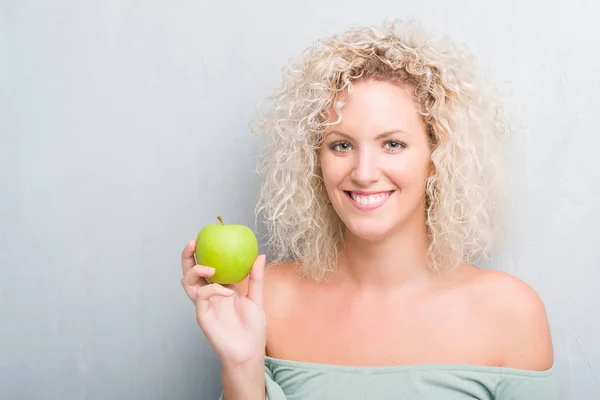 Giovane Donna Bionda Sfondo Grigio Grunge Mangiare Mela Verde Con — Foto Stock