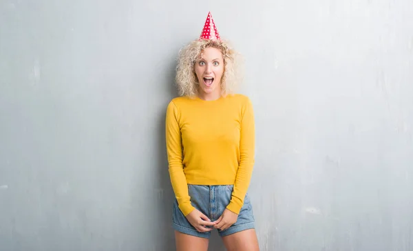 Junge Blonde Frau Über Grunge Grauer Wand Mit Geburtstagsmütze Verängstigt — Stockfoto