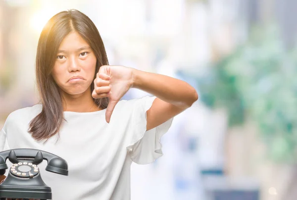 怒った顔 ダウン親指で嫌悪感を示すマイナス記号 拒絶反応の概念と分離の背景に Vintagera 電話を保持している若いアジア女性 — ストック写真