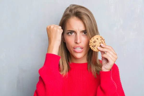 Hermosa Joven Mujer Sobre Grunge Gris Pared Comer Chocolate Chip —  Fotos de Stock