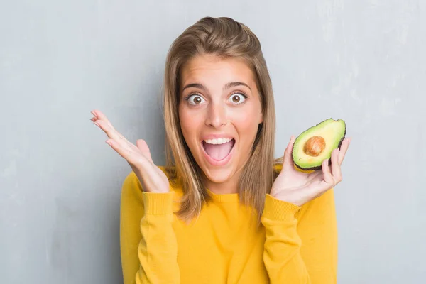 Beautiful Young Woman Grunge Grey Wall Eating Avocado Very Happy — Stock Photo, Image